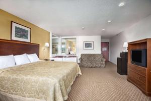 a hotel room with a bed and a television at Super 8 by Wyndham Canton/Livonia Area in Canton