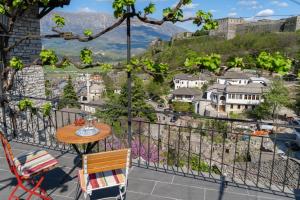 een tafel en stoelen op een balkon met uitzicht op de stad bij Belaj's House in Gjirokastër