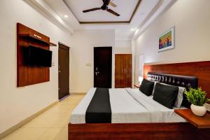 a bedroom with a large bed and a flat screen tv at Hotel Franklein Suites At Delhi Airport in New Delhi