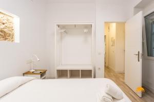 Habitación blanca con cama y ventana en Bajo el Falla by Cadiz Time, en Cádiz