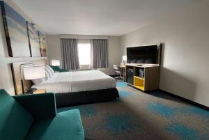 a hotel room with a bed and a flat screen tv at Days Inn & Suites by Wyndham of Morris in Morris
