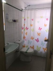 baño con aseo y cortina de ducha con mariposas en Hostal Tahiti RS, en Salou