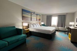 a hotel room with a bed and a couch at Days Inn & Suites by Wyndham of Morris in Morris