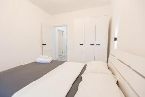 biała sypialnia z 2 łóżkami i białymi szafkami w obiekcie Уютная двухкомнатная квартира w mieście Kokczetaw
