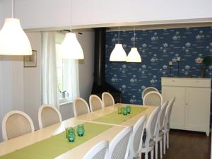 uma sala de jantar com uma mesa longa e cadeiras brancas em Kyrkekvarn Stugby em Sandhem