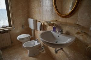 uma casa de banho com um lavatório, um WC e um espelho. em Casa Vicino em Cantalupo Ligure