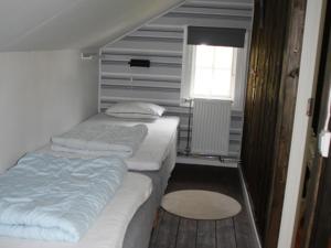 um pequeno quarto com 2 camas e uma janela em Kyrkekvarn Stugby em Sandhem