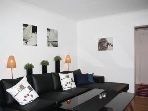 uma sala de estar com um sofá preto e uma mesa em Kyrkekvarn Stugby em Sandhem