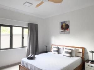 a bedroom with two beds and a window at Beachwalk Residence - Trou-aux-Biches in Trou aux Biches