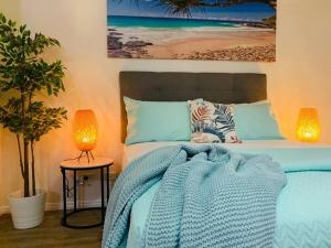 a bedroom with a bed with a blue blanket and two lamps at Paradise Island Resort & Gardens - Gold Coast Surfers Paradise in Gold Coast +37 photos