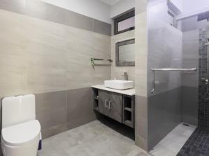 a bathroom with a toilet and a sink and a shower at Beachwalk Residence - Trou-aux-Biches in Trou aux Biches