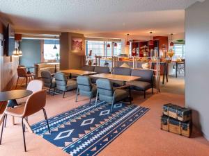 un ristorante con tavoli e sedie in una stanza di IBIS STYLES Rouen Parc Expos Zenith a Saint-Étienne-du-Rouvray