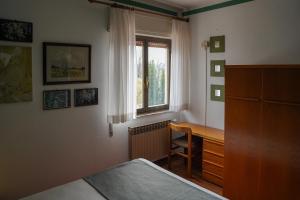 a bedroom with a desk and a window at Casa Vicino in Cantalupo Ligure