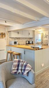 a kitchen with a couch and a counter top at Lobster Cove, 50 yards from the sea in Port Isaac