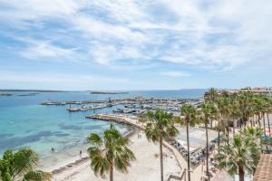 vistas a una playa con palmeras y un puerto en Beachfront Penthouse, en Colònia De Sant Jordi