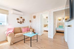 una sala de estar con un sofá y una mesa en Beachfront Penthouse, en Colònia De Sant Jordi