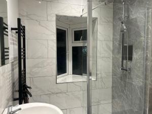 a bathroom with a shower with a sink and a mirror at WV1 Bridge House - 3 Bedrooms, sleeps 6 free Parking - New Cross - Bentley Bridge - 欢迎 in Wolverhampton