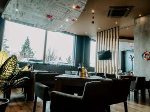 um restaurante com mesas e cadeiras e uma grande janela em Ibis Sofia Airport Hotel em Sófia