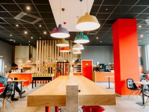 a dining room with a large wooden table and chairs at Ibis Sofia Airport Hotel in Sofia