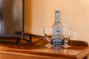 a bottle of water and two wine glasses on a table at Tamahuche Hotel Rural in Vallehermoso