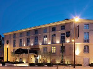 un edificio con una luz de la calle delante de él en Grand Hôtel Roi René Aix en Provence Centre - MGallery, en Aix-en-Provence