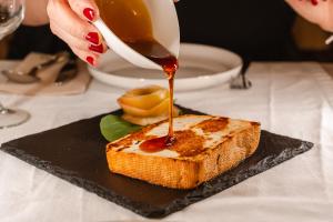 a person is pouring sauce onto a piece of toast at Tamahuche Hotel Rural in Vallehermoso