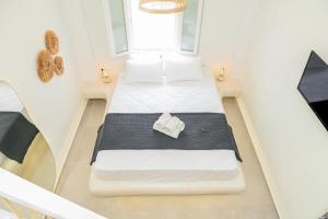 a small room with two beds and a window at Seaclusion Santorini in Kamari