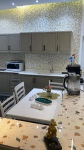 a kitchen with a table and a counter top at شقة مفروشة فاخرة in Al Ḩawīyah