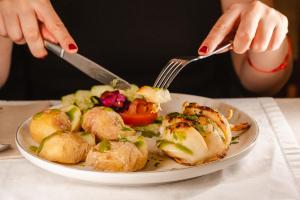 a person eating a plate of food with a fork and knife at Tamahuche Hotel Rural in Vallehermoso