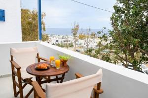 a table and chairs on a balcony with a view of the ocean at Seaward in Kamari