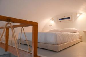 a white bedroom with a bed with a swing at Seaward in Kamari