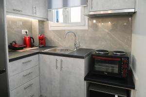 a small kitchen with a sink and a stove at Seaward in Kamari