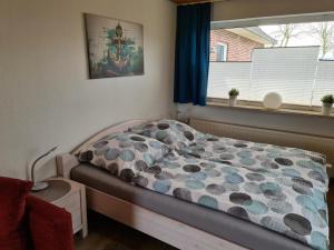 a bed in a bedroom with a window at Ferienwohnung ZWEI nähe Büsum in Oesterdeichstrich