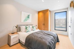 um quarto com uma cama e uma janela em Tottenham- Exquisite 4-Bed Retreat with Ping Pong and Pool - Sleeps 7, Free Parking, Contractors & Long Stays Welcome em Londres
