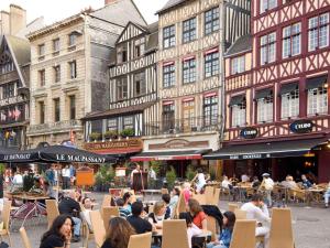 a group of people sitting at tables in a street with buildings at ibis budget Rouen Parc des Expos Zenith in Saint-Étienne-du-Rouvray