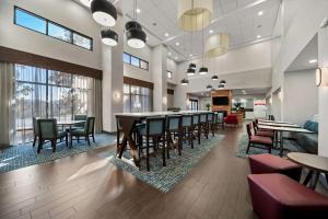 - une salle à manger avec des tables, des chaises et des fenêtres dans l'établissement Hampton Inn & Suites Opelika-I-85 Auburn Area, à Opelika