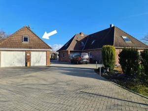 a house with a driveway and a garage at Ferienwohnung EINS nähe Büsum in Oesterdeichstrich