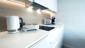 una cocina con cafetera en una encimera en Apartament Deluxe Sea View PINEA 606 en Pobierowo