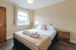 een slaapkamer met een bed met handdoeken erop bij Finest Retreats - Netley Hall - Poppy in Dorrington