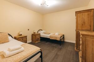 a bedroom with two beds and two night stands at Finest Retreats - Netley Hall - Rosemary in Dorrington