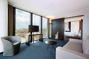 a hotel room with a couch and a bed and window at HYPERION Hotel Basel in Basel