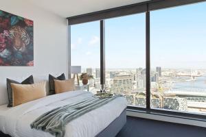 a bedroom with a bed and a large window at A Modern 2BR Apt with Harbour Views FREE Parking in Melbourne