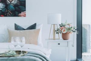 a bedroom with a bed with two wine glasses on a table at A Modern 2BR Apt with Harbour Views FREE Parking in Melbourne