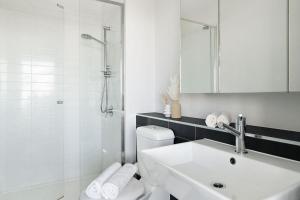 a bathroom with a toilet and a sink and a shower at A Modern 2BR Apt with Harbour Views FREE Parking in Melbourne