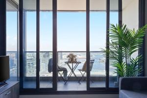 a room with a balcony with a table and chairs at A Modern 2BR Apt with Harbour Views FREE Parking in Melbourne