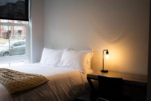 1 dormitorio con 1 cama con lámpara y ventana en Modern 4-BR Condos at Current at Latimer Square, en Bloomington