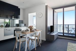 a kitchen with a table and chairs in a kitchen at A Modern 2BR Apt with Harbour Views FREE Parking in Melbourne
