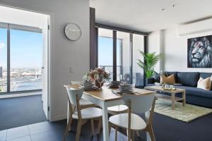 a dining room and living room with a table and chairs at A Modern 2BR Apt with Harbour Views FREE Parking in Melbourne