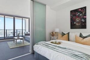 a bedroom with a large bed and a room with a view at A Modern 2BR Apt with Harbour Views FREE Parking in Melbourne