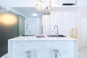 a white kitchen with a sink and a mirror at The Boutique Houses Milan - Galleria - With Private Parking in Milan